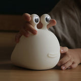 Child patting the slug night light to dim it