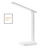 Foldable LED desk lamp beside a plant